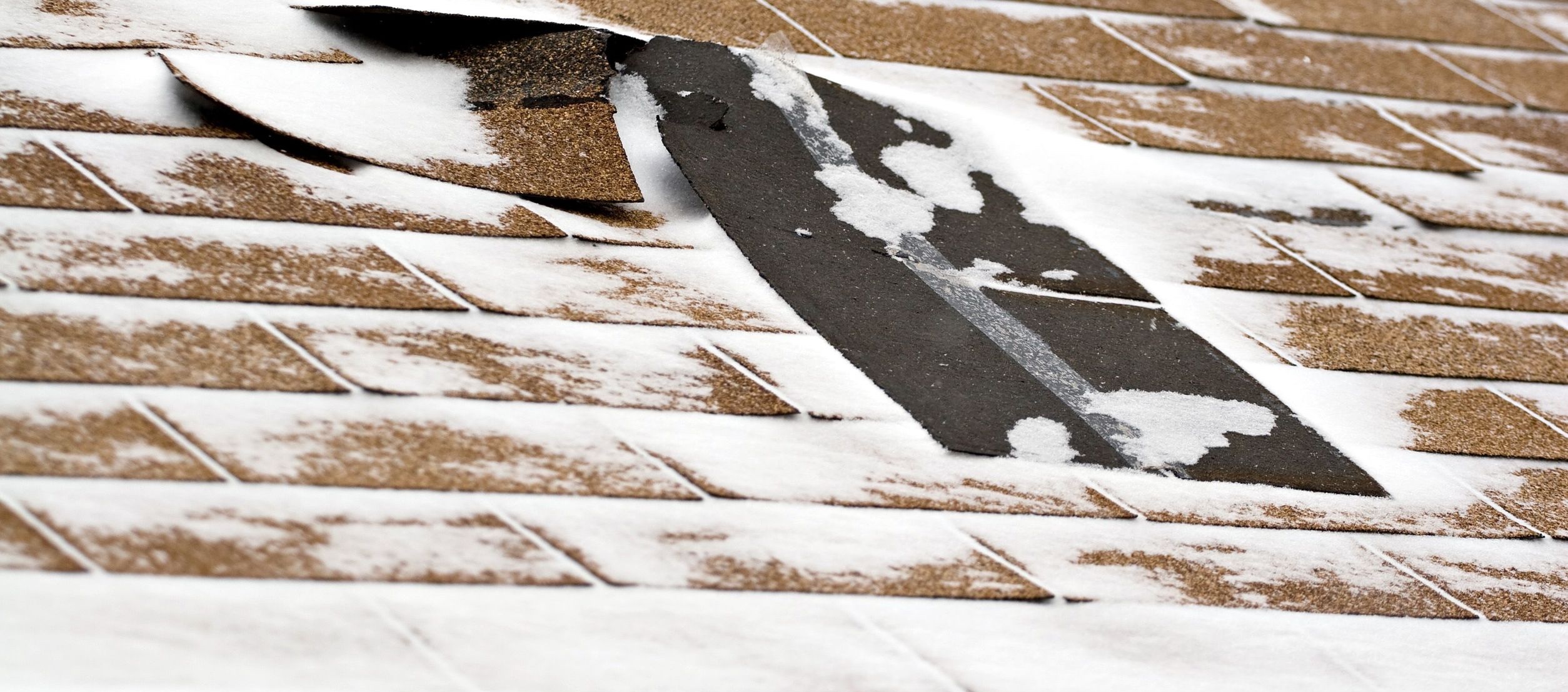 Snow covered roof with damages