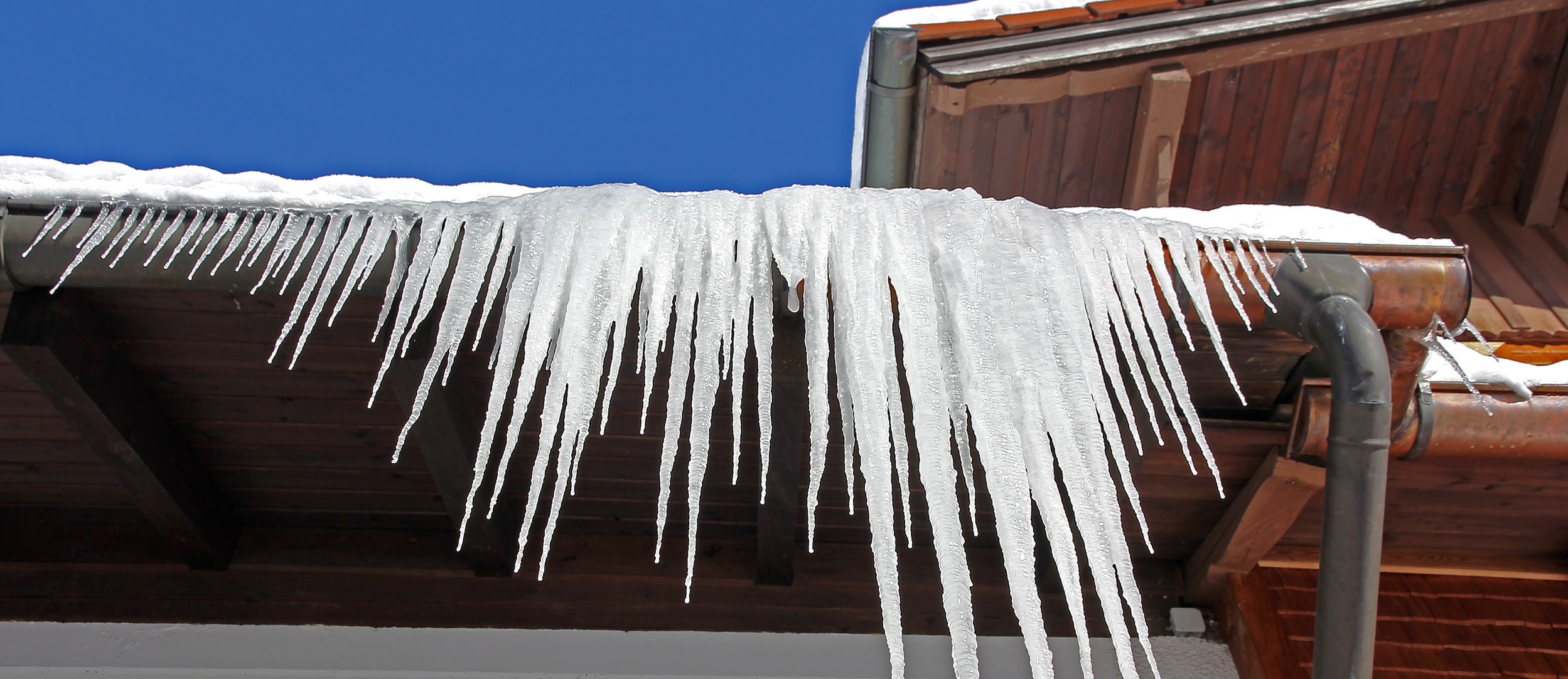 Large icicles hanging from a house roof