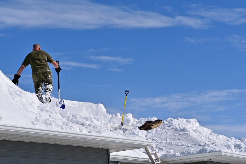 Snow is being removed from a roof with a shovel after a heavy snowfall in Park City, Utah