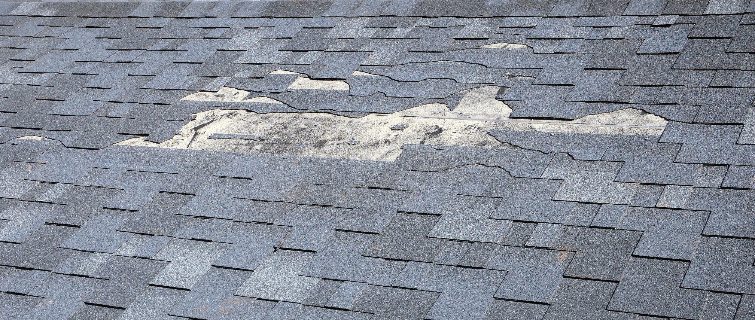 Ripped asphalt shingles on a roof