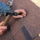 Roofer installing asphalt shingles